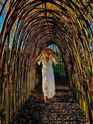 a woman in a white dress walking through a tunnel at Raj na Hektarach in Wysokie