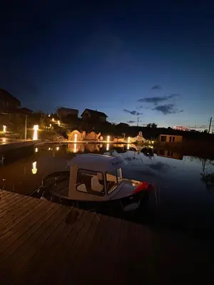 a boat is docked at a dock at night at Raj na Hektarach in Limanowa
