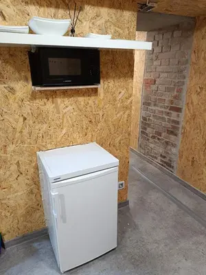 a white refrigerator in a room with a microwave at Kapsuła #2 Centrum in Kraków