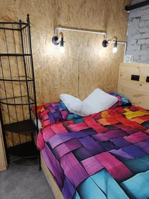 a bed in a room with a colorful quilt at Kapsuła #2 Centrum in Kraków