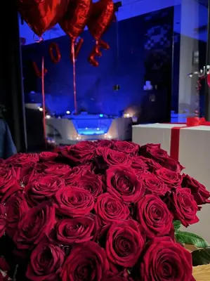 a large bouquet of red roses on a table at Jacuzzi & Relax by Leo Apartments Old Town in Kraków