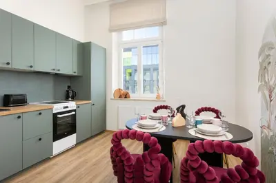 a kitchen with a table and two red chairs at Katie's Apartment in Kraków