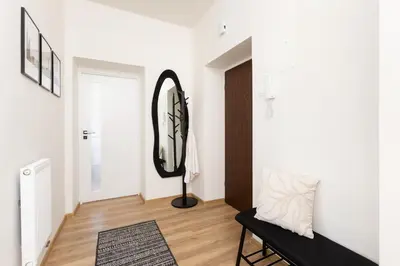 a hallway with a mirror and a black bench at Katie's Apartment in Kraków