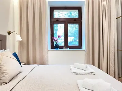 a bedroom with a bed and a window with towels at Secret Garden Kraków - Wonderful City Centre Apartment - Ground Floor - Quiet Location in Kraków