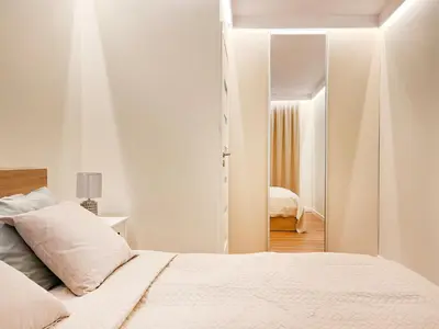 a white bedroom with a bed and a mirror at Secret Garden Kraków - Wonderful City Centre Apartment - Ground Floor - Quiet Location in Kraków