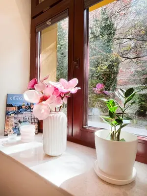three white vases with pink flowers on a window sill at Secret Garden Kraków - Wonderful City Centre Apartment - Ground Floor - Quiet Location in Kraków