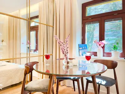 a dining room with a table and two glasses of wine at Secret Garden Kraków - Wonderful City Centre Apartment - Ground Floor - Quiet Location in Kraków