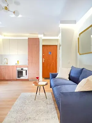 a living room with a blue couch and a table at Secret Garden Kraków - Wonderful City Centre Apartment - Ground Floor - Quiet Location in Kraków