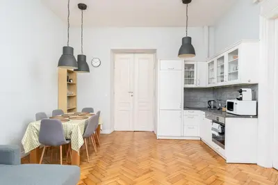 a kitchen and dining room with a table and chairs at Dietla Avenue Charm Apartment by BookingHost in Kraków