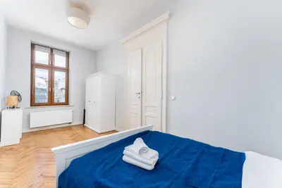 a bedroom with a blue bed with towels on it at Dietla Avenue Charm Apartment by BookingHost in Kraków