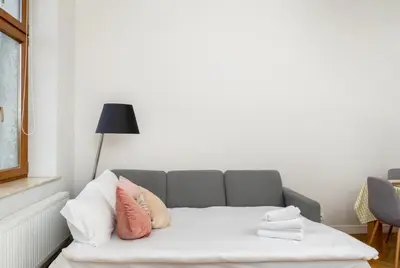 a living room with a couch with pillows on it at Dietla Avenue Charm Apartment by BookingHost in Kraków