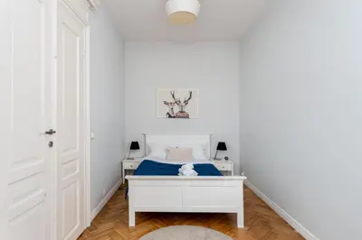 a bedroom with a white bed and a white desk at Dietla Avenue Charm Apartment by BookingHost in Kraków