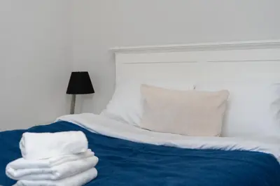 a bed with two white towels stacked on it at Dietla Avenue Charm Apartment by BookingHost in Kraków