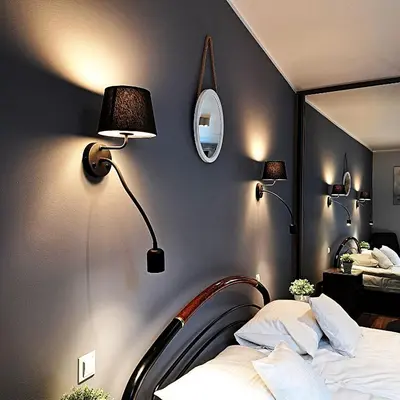 a bedroom with a bed and two lights on the wall at Luxury Modern Apartment in Kraków