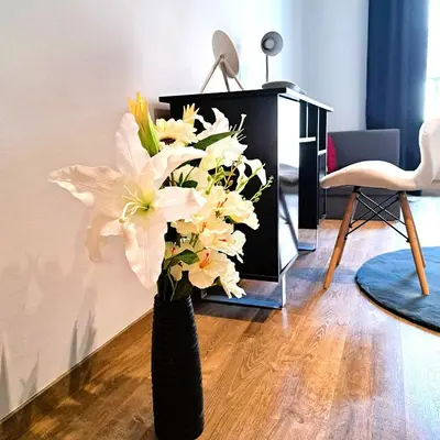 a black vase with white flowers in a living room at Luxury Modern Apartment in Kraków