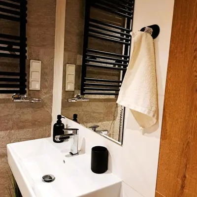 a bathroom with a white sink and a mirror at Luxury Modern Apartment in Kraków