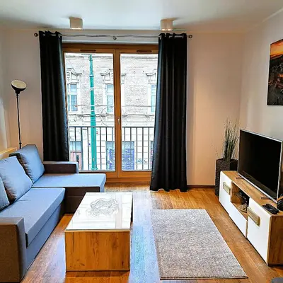 a living room with a couch and a tv at Luxury Modern Apartment in Kraków