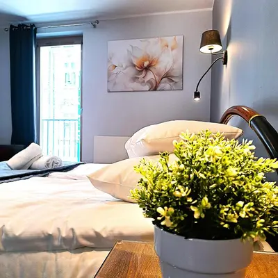 a bedroom with a bed and a table with flowers at Luxury Modern Apartment in Kraków