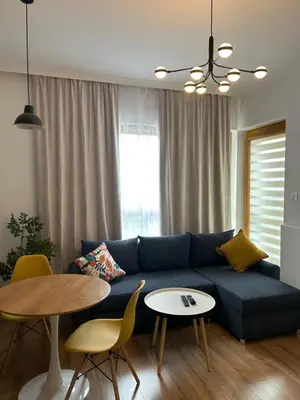 a living room with a blue couch and a table at HolidayHome Kraków Center in Kraków