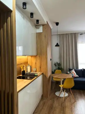 a kitchen and living room with a table and a couch at HolidayHome Kraków Center in Kraków