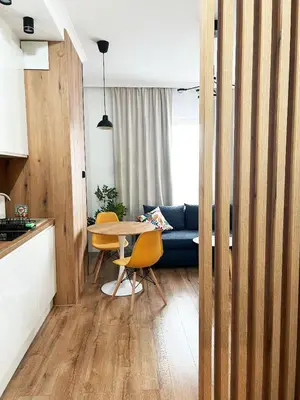 a living room with a table and a blue couch at HolidayHome Kraków Center in Kraków