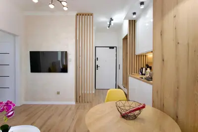 a kitchen and dining room with a round table and yellow chair at HolidayHome Kraków Center in Kraków