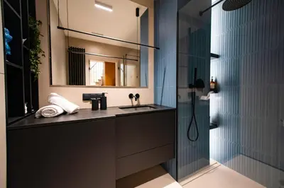 a bathroom with a sink and a mirror and a shower at Luxury penthouse with large terrace in Kraków