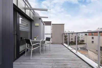 a balcony with a table and chairs on a building at Modern Apartment with Air Conditioning and Parking in Cracow by Noclegi Renters in Kraków
