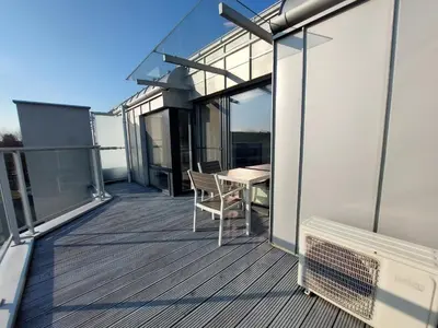 a balcony with a table and chairs on a building at Modern Apartment with Air Conditioning and Parking in Cracow by Noclegi Renters in Kraków