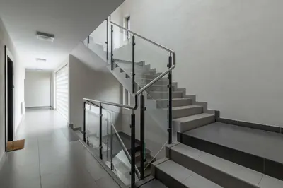 a staircase with glass railings in a house at Modern Apartment with Air Conditioning and Parking in Cracow by Noclegi Renters in Kraków