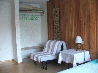 a bedroom with a chair and a table with a lamp at Uroczy Domek Z Ogrodem I Tarasem in Myślenice