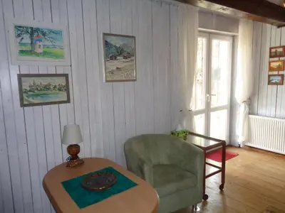 a living room with a table and a chair at Uroczy Domek Z Ogrodem I Tarasem in Myślenice