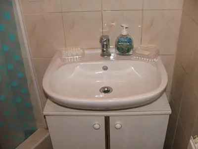 a bathroom sink with a bottle of soap on it at Uroczy Domek Z Ogrodem I Tarasem in Myślenice