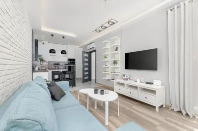 a living room with a blue couch and a tv at Nowoczesny & Klimatyzowany Apartament z Parkingiem by Noclegi Renters in Kraków