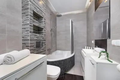 a bathroom with a tub and a sink and a toilet at Nowoczesny & Klimatyzowany Apartament z Parkingiem by Noclegi Renters in Kraków