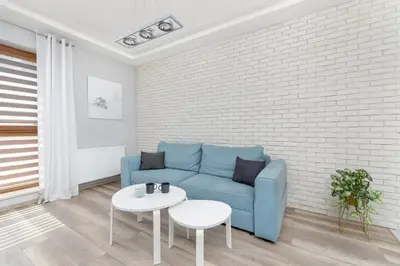 a living room with a blue couch and a table at Nowoczesny & Klimatyzowany Apartament z Parkingiem by Noclegi Renters in Kraków