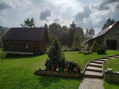 a yard with a house and a house with trees and plants at Domek Ciśniawa in Sidzina