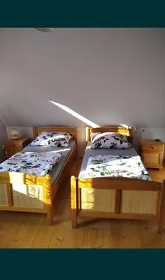 two twin beds in a room with a attic at Domek Ciśniawa in Sidzina