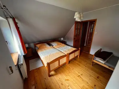 a bedroom with a bed and a wooden floor at Domek Ciśniawa in Sidzina