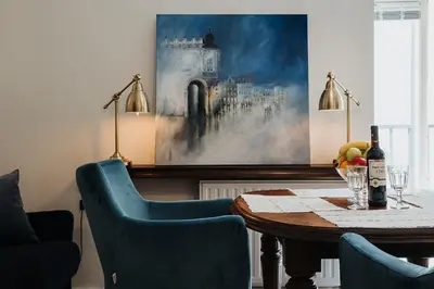 a dining room with a table and a painting on the wall at TOP Cracow Main Hub in Kraków