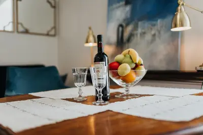 a bottle of wine and a bowl of fruit on a table at TOP Cracow Main Hub in Kraków