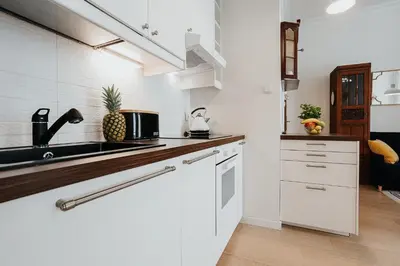 a white kitchen with a sink and a counter top at TOP Cracow Main Hub in Kraków