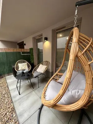 a hanging rattan swing chair in a living room at Cubicle 22 Garden & Free Parking in Kraków