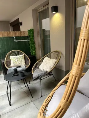 two wicker chairs and a table in a room at Cubicle 22 Garden & Free Parking in Kraków