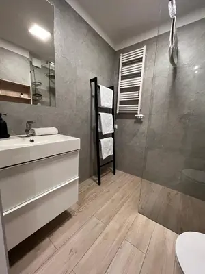 a bathroom with a sink and a glass shower at Cubicle 22 Garden & Free Parking in Kraków