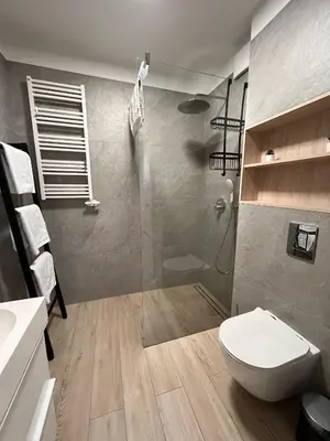 a bathroom with a toilet and a glass shower at Cubicle 22 Garden & Free Parking in Kraków