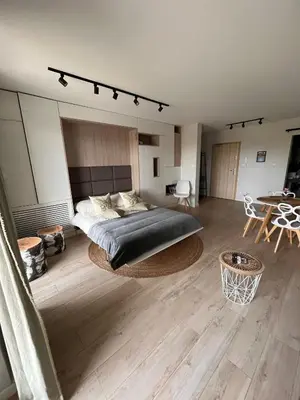 a bedroom with a large bed and a table at Cubicle 52 Terrace & Free Parking in Kraków