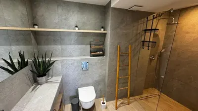 a bathroom with a shower and a toilet and a ladder at Cubicle 52 Terrace & Free Parking in Kraków