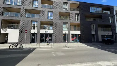 a large brick building with two people on a skateboard in the street at Cubicle 52 Terrace & Free Parking in Kraków