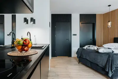 a kitchen and a bedroom with a bed and a bowl of fruit at Cubicle 72 Studio Big Terrace in Kraków